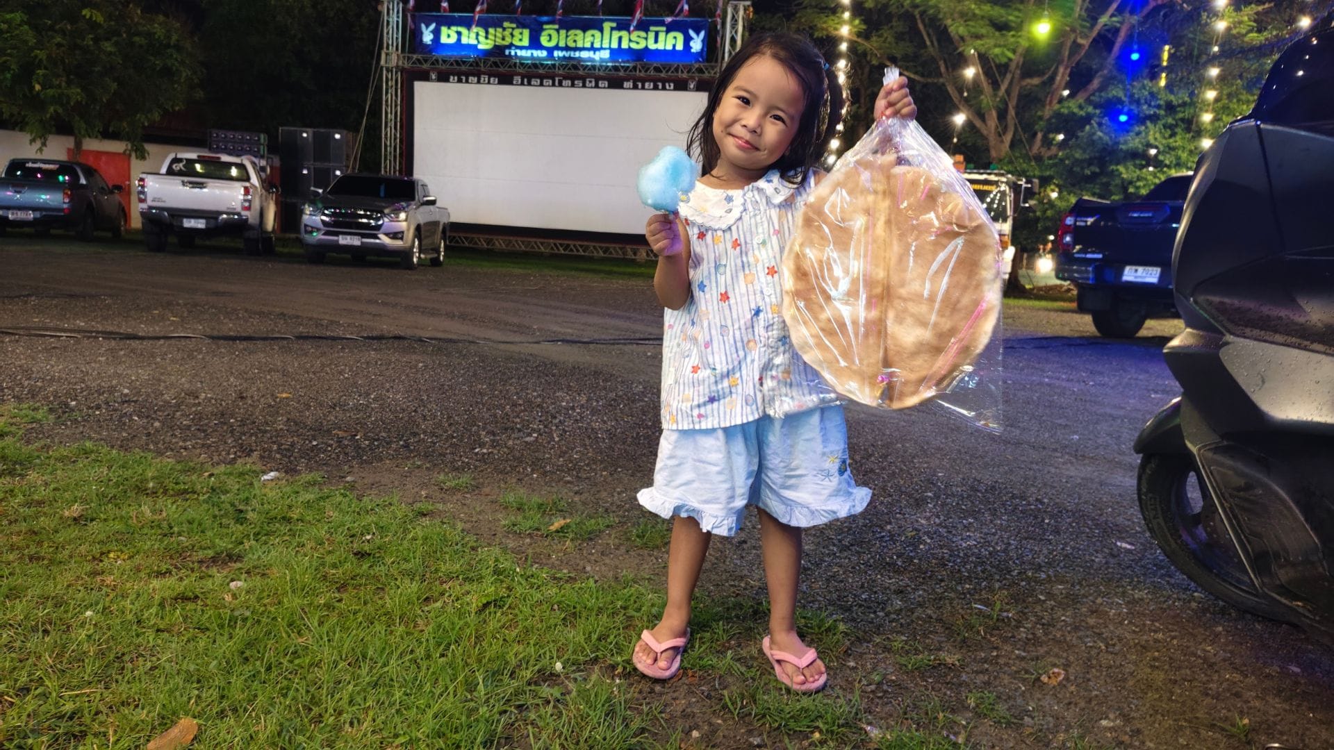 nang-klang-plaeng-เด็กหญิงถือขนมสายไหมและข้าวเกรียบว่าวหน้าจอหนังกลางแปลง วัดเขาทะโมน เพชรบุรี